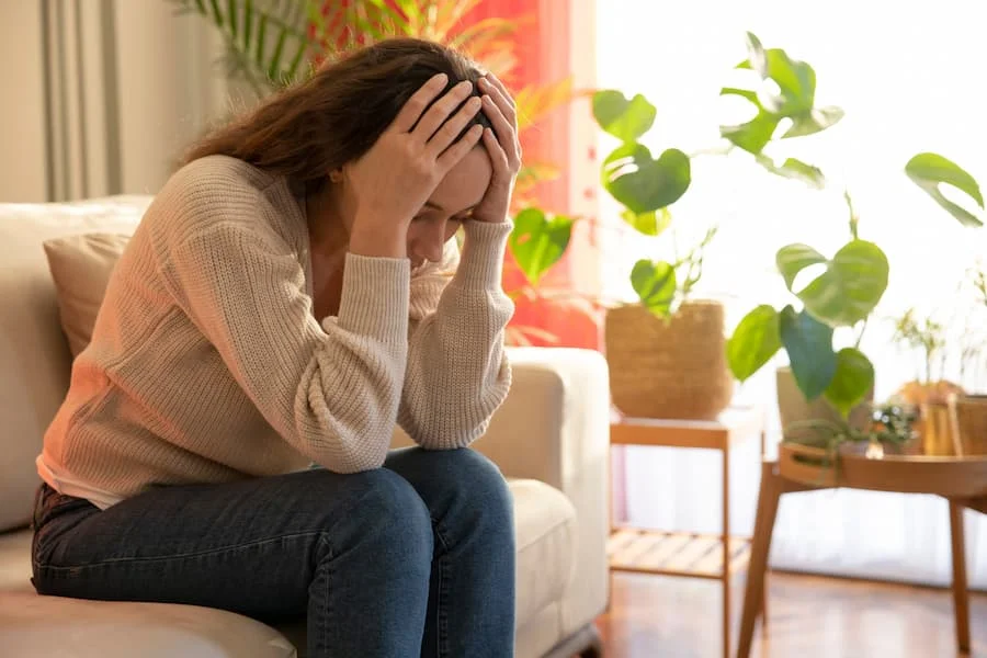 Mère épuisée, tenant sa tête, illustrant le burn-out parental, le baby-blues et la dépression post-partum