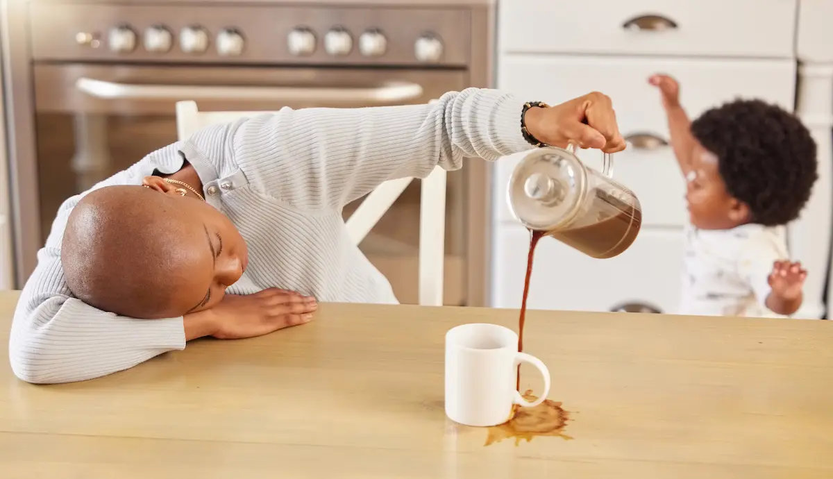 Maman dépassée renversant son café, illustrant un parent épuisé ayant besoin d’aide pour gérer la charge mentale