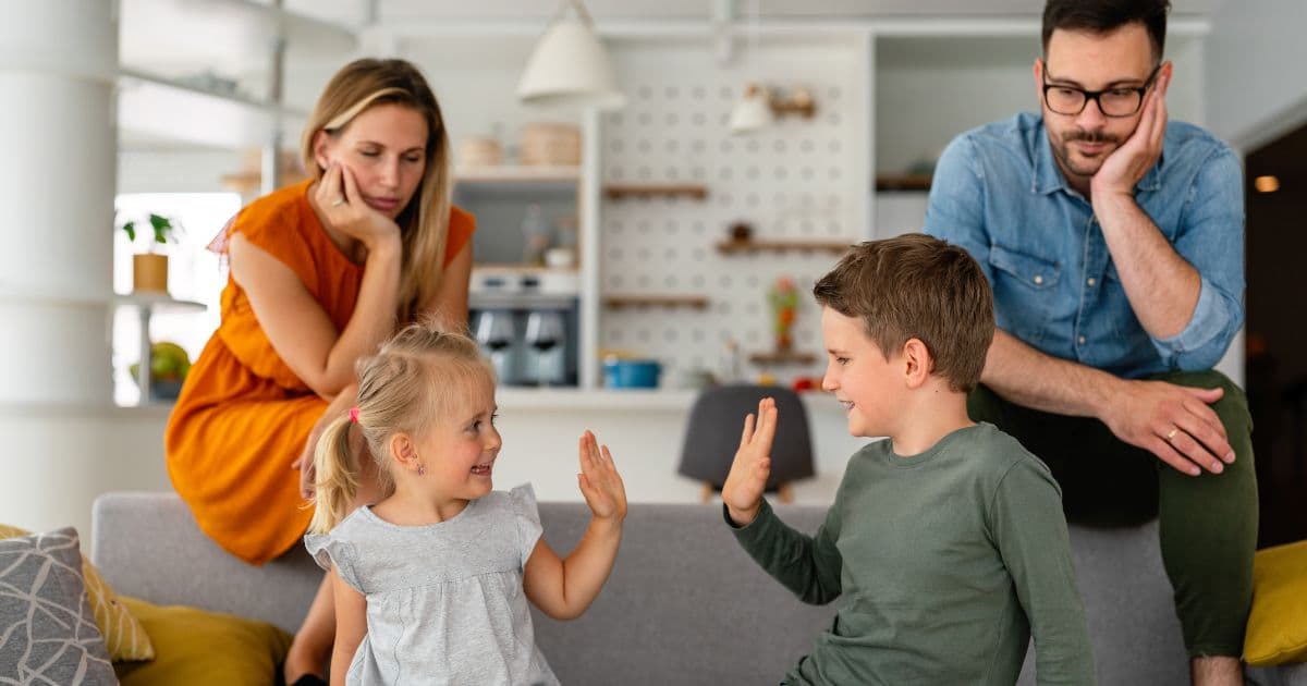 Parents fatigués à la maison avec leurs deux enfants, illustrant l’épuisement parental et la charge mentale familiale