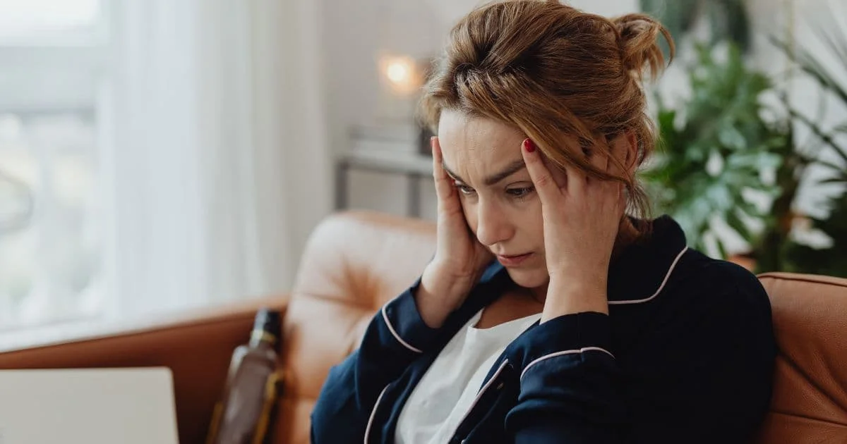 Personne se tenant la tête, submergée par la charge mentale, illustrant le burn-out parental et le besoin de thérapie pour burn-out parental