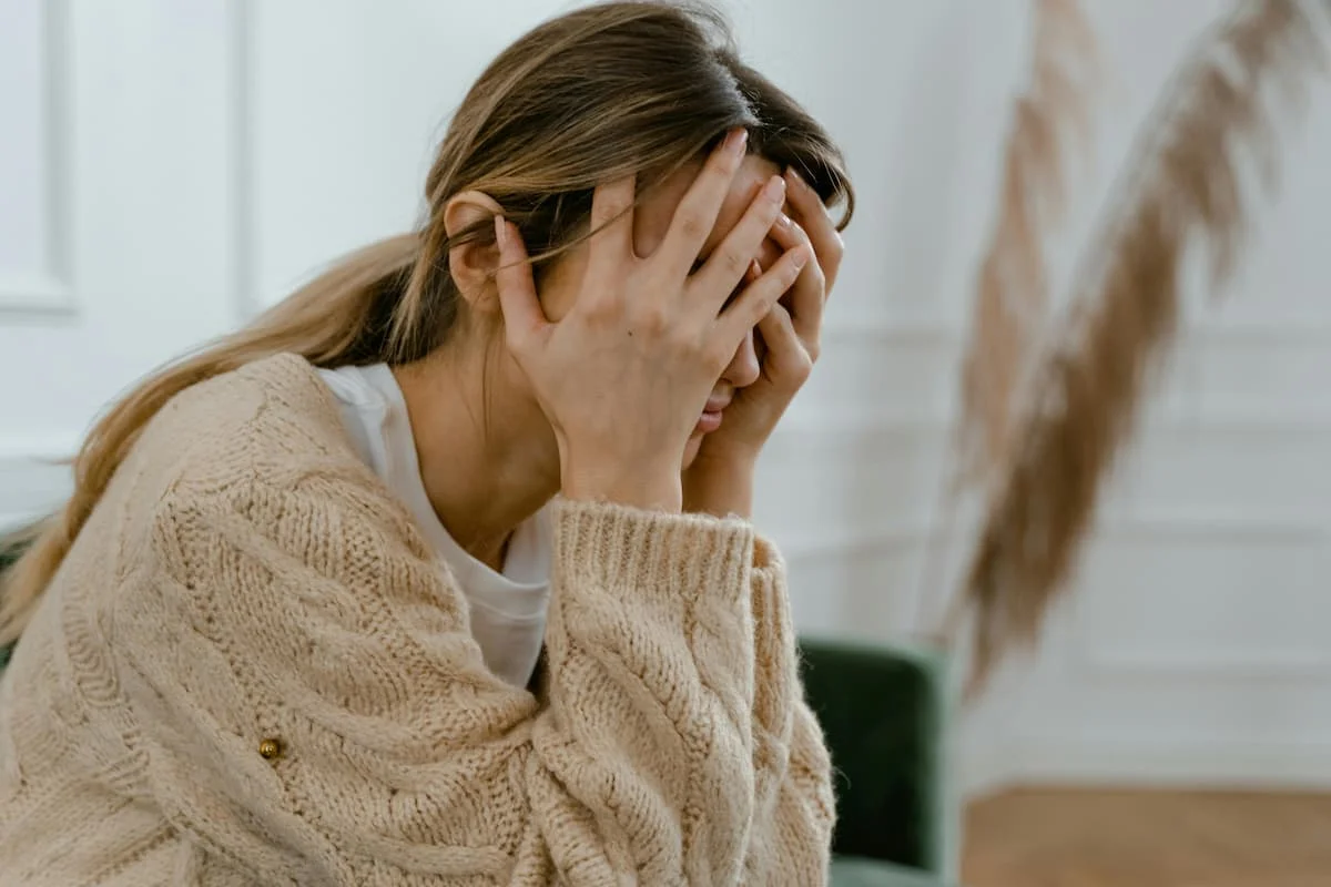 Femme épuisée les mains sur le visage illustrant le burn-out parental et le moment où consulter devient nécessaire