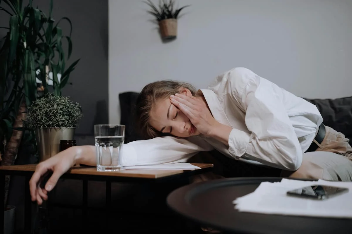 Employée fatiguée au travail montrant les risques de burn-out parental et l’impact de la parentalité en entreprise